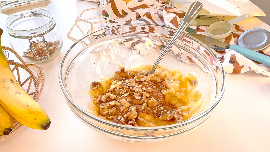 banana bread batter with crushed walnuts and brown sugar on banana mashed